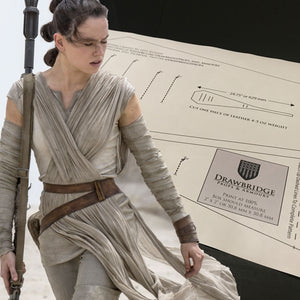 
                  
                    Rey from star wars, the force awakens in linen sand costume with leather cuff, belt, pouch holding staff. Pattern for leather cuff  from Drawbridge Props and Armoury in background.
                  
                